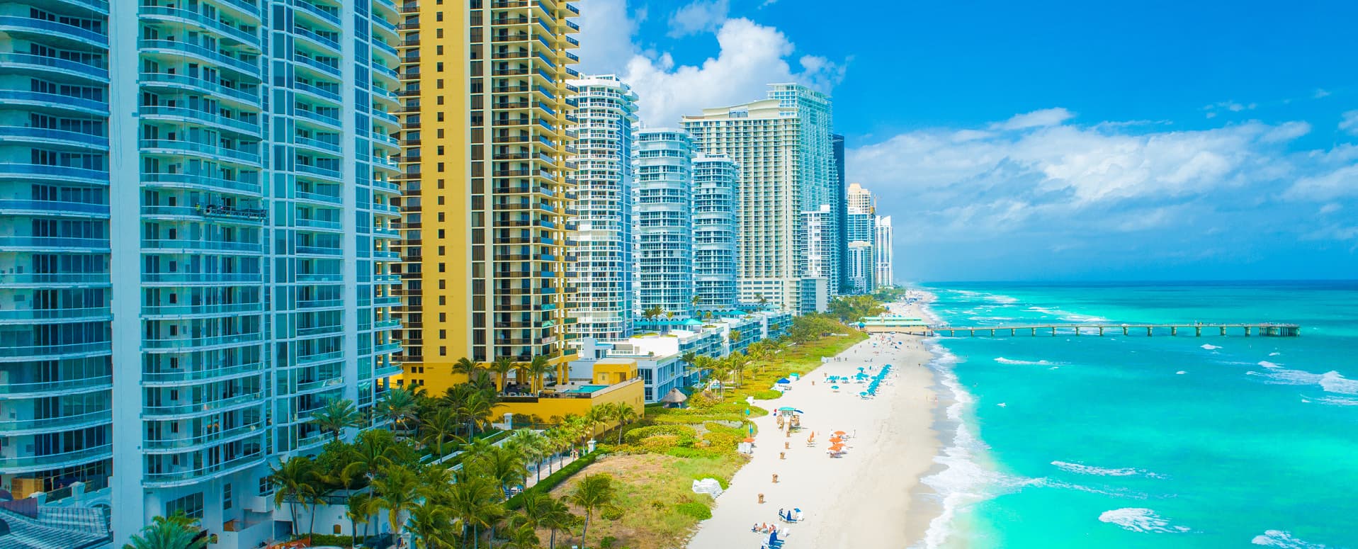 High-rise beachfront hotels and condominiums in Florida overlooking turquoise ocean waters and sandy beaches, illustrating “The Bellwether State: Florida’s CMBS Hotel Defaults as a National Indicator.”